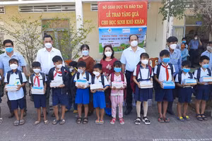 Lãnh đạo Sở GD&ĐT Cà Mau, nhà tài trợ cùng chính quyền địa phương trao quà cho học sinh.