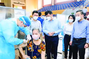 Bộ trưởng Bộ Y tế Nguyễn Thanh Long (đứng giữa) kiểm tra công tác tiêm chủng vaccine phòng COVID-19 tại Hà Nội. Ảnh: Trần Minh