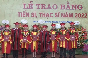 GS.TS Phạm Quang Trung - Giám đốc Học viện (thứ 4 từ phải qua trái) và PGS.TS Trần Hữu Hoan - Phó Giám đốc Học viện (thứ 2 từ trái qua phải) trao bằng tốt nghiệp và vòng nguyệt quế cho các tân tiến sĩ