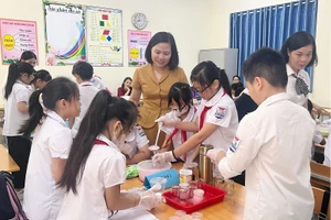 Bà Dương Hồng Minh và HS Trường Tiểu học Thị trấn Đồng Đăng trong một tiết thực nghiệm dạy học hoạt động trải nghiệm theo chủ đề STEM.