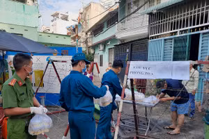 Lực lượng chức năng hỗ trợ cung cấp đồ ăn, thức uống cho cư dân ở khu phố 4 đường Phạm Phú Thứ Quận 6 đang bị phong tỏa. 