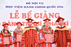 Thứ trưởng Bộ Nội vụ Triệu Văn Cường (bên trái) và Giám đốc Học viện Hành chính Quốc gia (bên phải) trao bằng cho các Tiến sĩ tại lễ bế giảng.