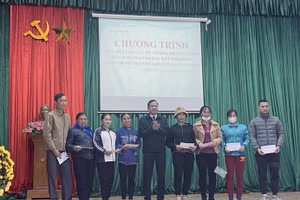 Ông Nguyễn Văn Thêm - Phó Giám đốc Sở GD&ĐT tặng quà cho đại diện các hộ gia đình chính sách, hộ nghèo trên địa bàn xã Trường Sơn.