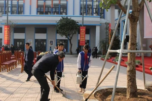 Bí thư Quận ủy Ba Đình - Hoàng Minh Dũng Tiến cùng học sinh trường THCS Thành Công trồng cây tại lễ phát động.