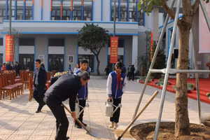 Bí thư Quận ủy Ba Đình - Hoàng Minh Dũng Tiến cùng học sinh trường THCS Thành Công trồng cây tại lễ phát động.