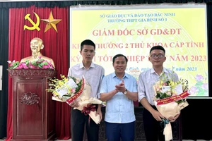 Ông Nguyễn Hữu Bình - Phó Giám đốc GD&ĐT Bắc Ninh tặng hoa chúc mừng 2 thủ khoa Lê Đình Sáng và Nguyễn Khắc Thái.