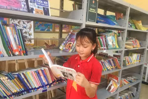 Cao Thị Bảo Ngọc trường Tiểu học Phú Lương tại thư viện sách nhà trường.