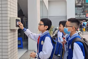 Học sinh điểm danh qua cổng điện tử bằng thẻ từ.