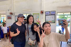 Các em ở Làng Hy Vọng chụp ảnh “selfie” cùng với các nữ thủy thủ tàu sân bay. (Ảnh: Hoàng Vinh)