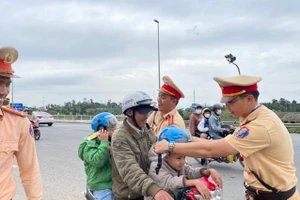 CSGT Đà Nẵng tặng mũ bảo hiểm cho các em nhỏ theo ba mẹ về quê ăn Tết. Ảnh: Công an Đà Nẵng. 