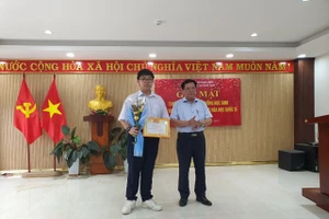 Ông Thái Viết Tường - Giám đốc Sở GD&ĐT tỉnh Quảng Nam tặng giấy khen vinh danh em Đỗ Phú Quốc. Ảnh: Sở GD&ĐT tỉnh Quảng Nam. 