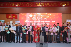 PGS.TS Vũ Thị Phương Anh (áo dài đỏ) - Hiệu trưởng Trường Cao đẳng Quảng Nam tặng hoa và quà tri ân các cựu giáo chức. 