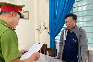 Cơ quan CSĐT Công an quận Ngũ Hành Sơn tống đạt quyết định khởi tố bị can đối với Nguyễn Đức Khởi. Ảnh: Bình Anh.