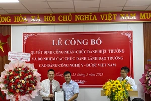 Ông Đào Trọng Độ - Vụ trưởng Vụ Đào tạo thường xuyên, Tổng cục Giáo dục nghề nghiệp (Bộ Lao động – Thương binh & Xã hội) đã trao quyết định công nhận chức danh Hiệu trưởng Trường Cao đẳng Công nghệ Y – Dược Việt Nam cho Thạc sĩ Nguyễn Văn Ánh (bìa trái). Ảnh: Hoàng Vinh. 