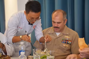 Đầu bếp Việt Nam hướng dẫn một sĩ quan của Hải quân Hoa Kỳ cách thưởng thức món mỳ Quảng. Ảnh: Vinh Hoàng. 