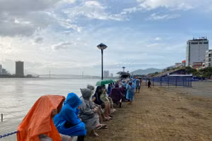 Bất chấp trời mưa, người dân và du khách mặc áo mưa để chờ xem pháo hoa. Ảnh: Hoàng Vinh. 