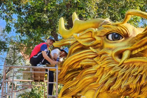 Giáo viên và học sinh lắp ráp lại linh vật Rồng. (Ảnh: TT)