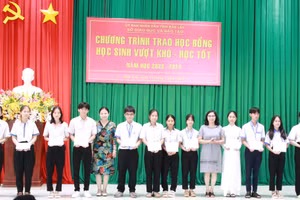 Ban tổ chức trao học bổng cho học sinh. (Ảnh: TT)
