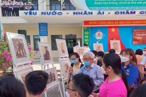 Học sinh Trường THCS Nguyễn Văn Linh (Hòa Vang) nghe họa sĩ - nhà điêu khắc Phạm Hồng - nhân chứng trực tiếp tham gia chiến đấu tại chiến trường khu V kể chuyện tại triển lãm Ký họa chiến trường