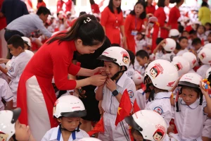 Hướng dẫn học sinh đội mũ bảo hiểm theo qui định.