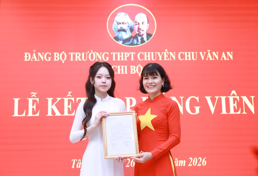 Nhà giáo Nguyễn Thị Nhiếp trao quyết định kết nạp Đảng cho Đảng viên mới.