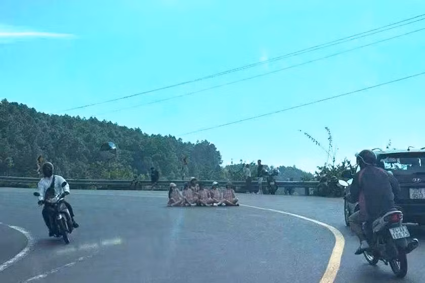 Nhóm phụ nữ bất chấp nguy hiểm ngồi giữa đường trên đèo Hải Vân chụp ảnh.
