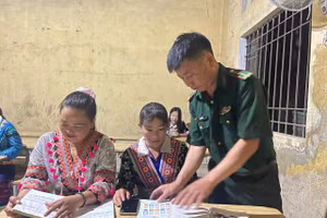 Thầy giáo Hơ Văn Di tận tình hướng dẫn bà con tập đọc.