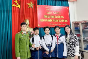 Ba học sinh trong số bốn học sinh nhặt được bọc tiền cùng cô giáo đến giao lại cho cơ quan công an.