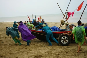 Ngư dân Thanh Hoá hối hả đưa thuyền lên bờ trước khi bão số 3 đổ bộ.