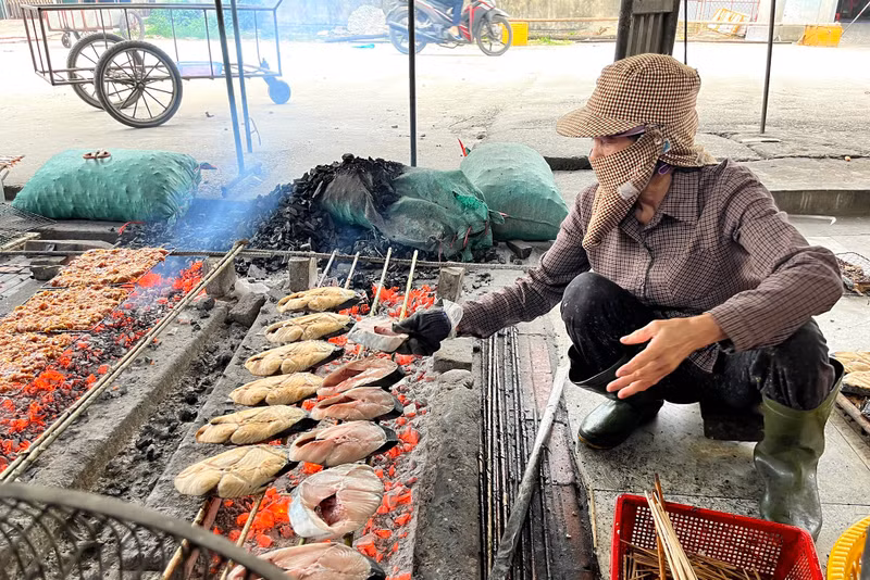 Để giảm bớt cái nóng, người nướng thường phải trùm kín mít từ đầu đến chân. (Ảnh: Phạm Tâm) Nghề nướng cá biển ở Nghệ An đắt khách dịp cuối năm