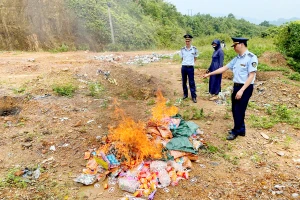 Lực lượng QLTT cùng chủ cơ sở kinh doanh tiến hành tiêu hủy số hàng hóa vi phạm.