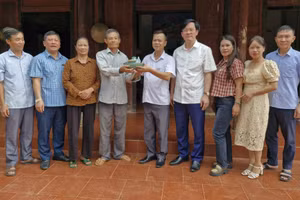 Ông Nguyễn Hữu Long (thứ 4 từ trái qua) bàn giao cổ vật cho chính quyền địa phương.