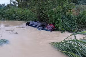 Chiếc ô tô bị lũ cuốn trôi.