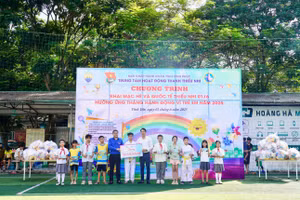 Ông Tạ Thanh Tùng – Giám đốc Trung tâm Hoạt động Thanh thiếu nhi tỉnh Vĩnh Phúc (áo xanh) cùng nhà tài trợ tặng quà cho các em thiếu nhi.