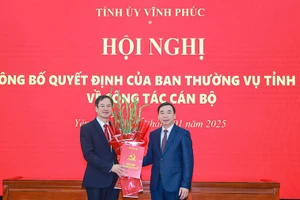 Phó Bí thư Thường trực Tỉnh ủy Vĩnh Phúc Bùi Huy Vĩnh (phải) trao Quyết định và tặng hoa chúc mừng ông Lại Hữu Tuyển.