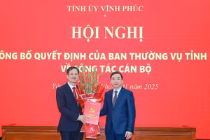 Phó Bí thư Thường trực Tỉnh ủy Vĩnh Phúc Bùi Huy Vĩnh (phải) trao Quyết định và tặng hoa chúc mừng ông Lại Hữu Tuyển.