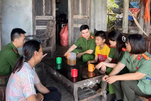 Cán bộ Công an xã Thanh Sơn thăm hỏi, động viên cháu Dương. 