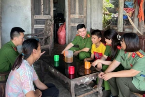 Cán bộ Công an xã Thanh Sơn thăm hỏi, động viên cháu Dương. 