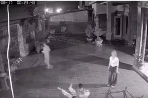 Hình ảnh Hà Thị Lai Hạ (áo trắng) nhìn chồng gục ngã dưới sân vẫn tỏ thái độ tức tối, mắng nạn nhân. (ảnh cắt từ clip).