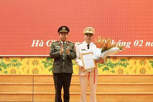 Đại tá Nguyễn Đức Thuận, Giám đốc Công an tỉnh Hà Giang trao quyết định và tặng hoa chúc mừng Thượng tá Nguyễn Mạnh Hùng.