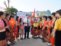 Thầy Nguyễn Lê Tú - giáo viên Trường Phổ thông nội trú TH&THCS Anh Sơn (Nghệ An) đón học sinh từ bản Cao Vều. Ảnh: Hồ Lài