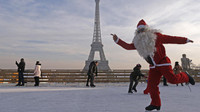Santa Claus trượt băng tạo dáng trước tháp Eiffel, Paris (Ảnh: Jacky Naegelen)