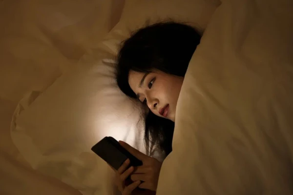 Mắt dán chặt vào màn hình điện thoại, số lần chớp mắt giảm gây ra khô mắt. (Ảnh: ITN)