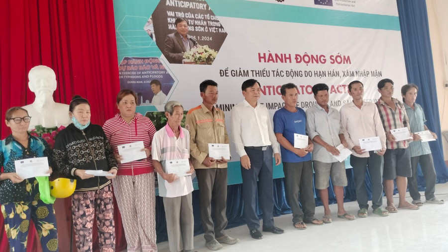 Ông Nguyễn Hoàng Hiệp, Thứ trưởng Bộ NN&amp;PTNT trao tiền hỗ trợ cho người dân.