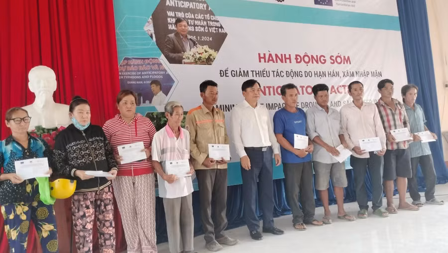 Ông Nguyễn Hoàng Hiệp, Thứ trưởng Bộ NN&amp;PTNT trao tiền hỗ trợ cho người dân.