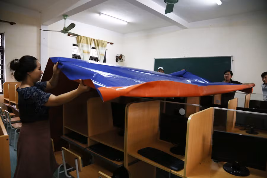 Dùng bạt che các thiết bị máy tính phòng tin học tại trường THCS Lý Trạch (Bố Trach - Quảng Bình).