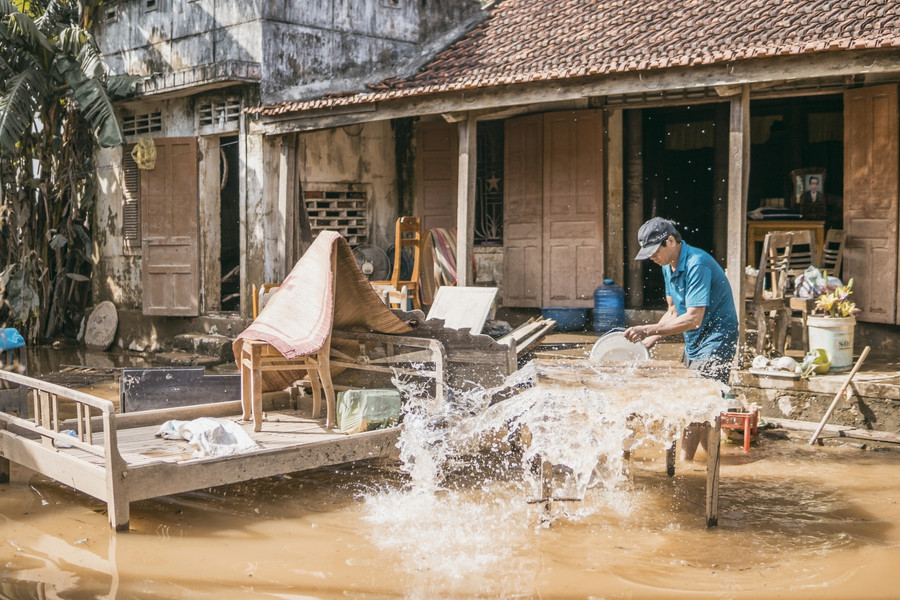 Người dân dọn dẹp bùn đất sau lũ (Ảnh Bùi Cường)