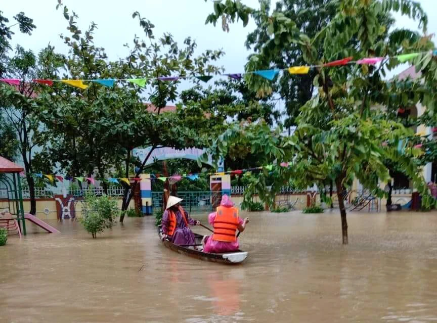 Giáo viên Trường mầm non Kiến Giang (Lệ Thuỷ - Quảng Bình) chèo đò vào trường để chống lũ.