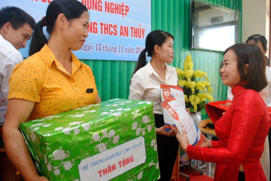 Bà Đặng Thị Trà, hiệu trưởng trường THCS Chu Văn An (thuộc hệ thống giáo dục Chu Văn An - Quảng Bình) tặng quà cho những giáo viên khó khăn của trường THCS An Thuỷ (Lệ Thuỷ - Quảng Bình)