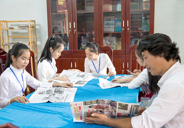 Thầy giáo và học sinh trường trường THCS&THPT Việt Trung tham gia đọc sách báo tại thư viện